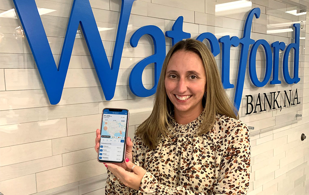 Young woman shows off the debit card management app on her phone.