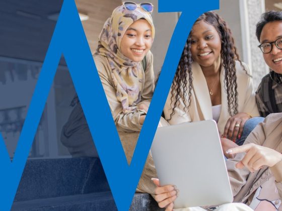 A group of GenZ friends looking at an iPad.