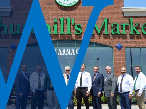 A group of Waterford bankers pose with staff in front of Walt Churchill's Market.