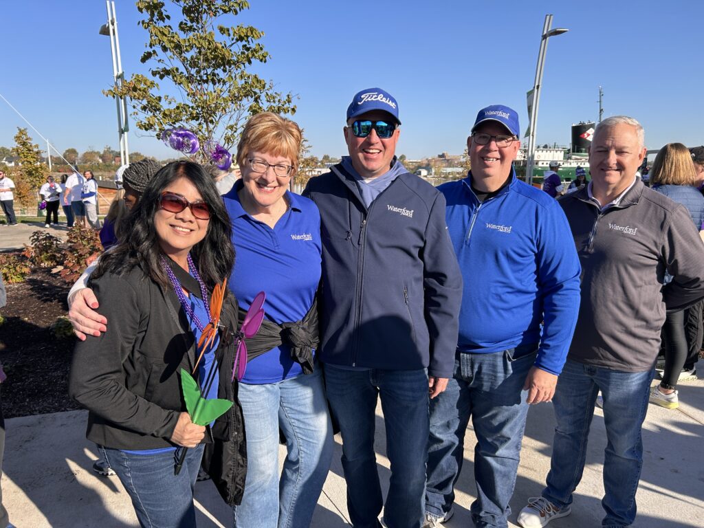 A group of five Waterford employees stand and smile for a photo after the Alzheimer Walk.