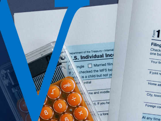 Close-up of IRS Form 1040 with a calculator and a large blue ‘W’ graphic overlay.