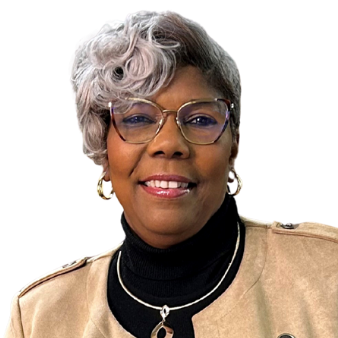 Rena Commons smiles at the camera wearing glasses and a tan jacket against a white background.