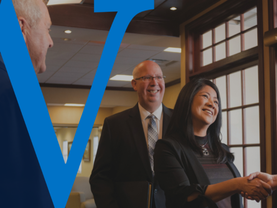 Business banking client shakes hands with a Waterford Bank team member during a business deposit transition meeting.