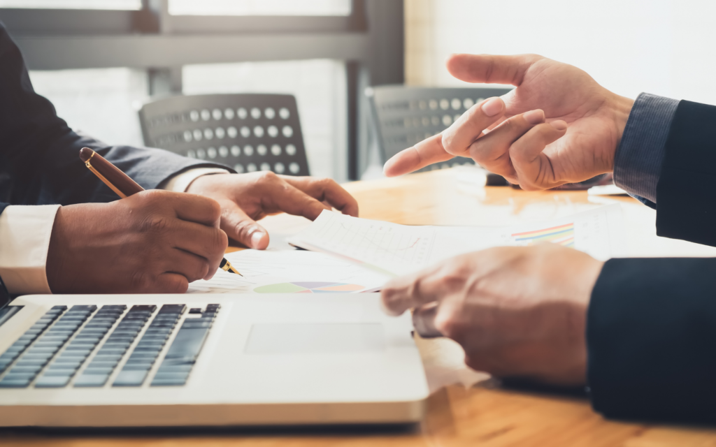 Business professionals review documents during a business deposit transition meeting about account visibility and payment updates.