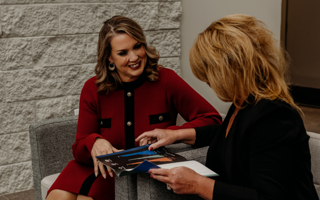 Two business banking professionals review business deposit transition materials during a meeting.