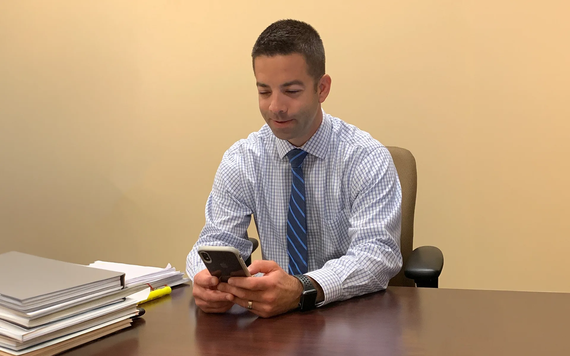 Banker reviews documents on his phone.